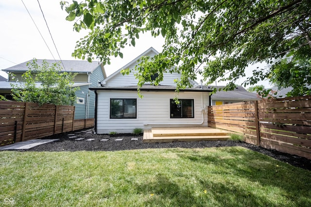 back of property featuring a deck, a yard, and a fenced backyard