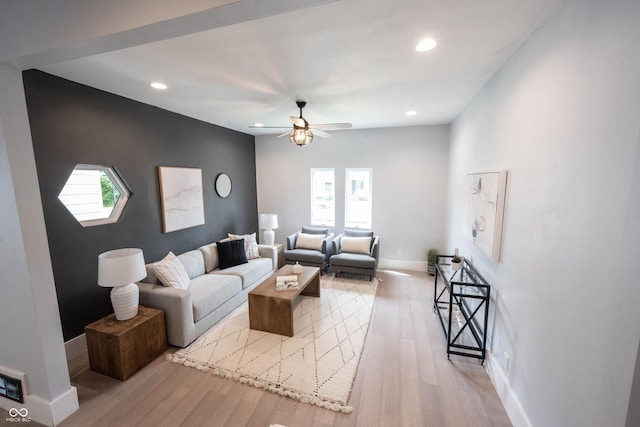 living room featuring recessed lighting, a ceiling fan, baseboards, and light wood-type flooring