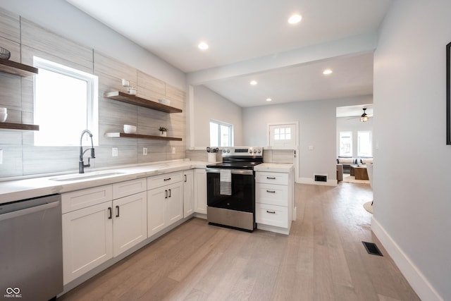 kitchen featuring a sink, open shelves, visible vents, backsplash, and appliances with stainless steel finishes