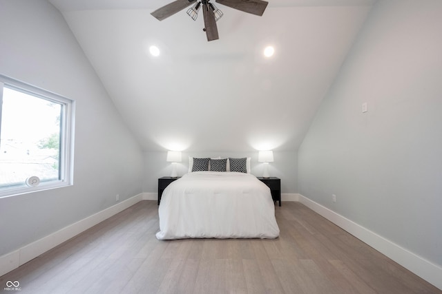 bedroom with wood finished floors, ceiling fan, vaulted ceiling, and baseboards