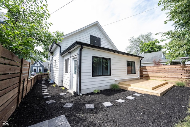 rear view of house with a wooden deck and a fenced backyard