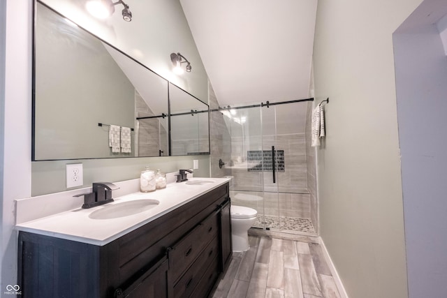 full bath featuring toilet, a stall shower, a sink, and wood finished floors