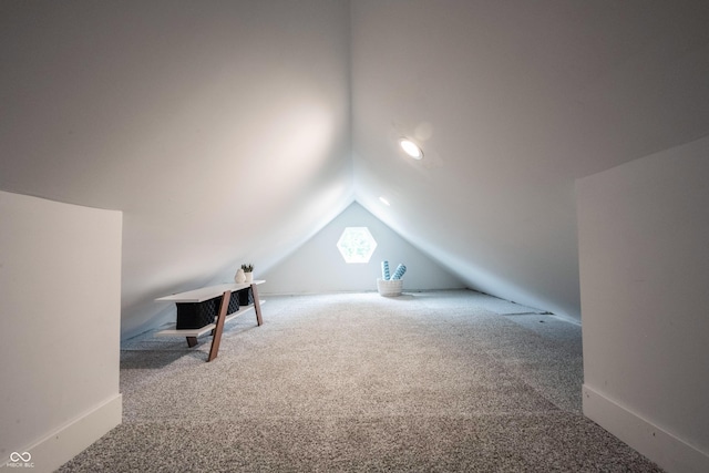 additional living space with lofted ceiling and carpet flooring