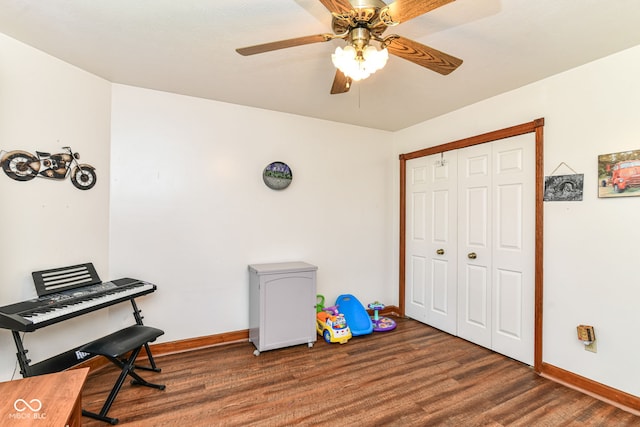 recreation room featuring baseboards, a ceiling fan, and wood finished floors