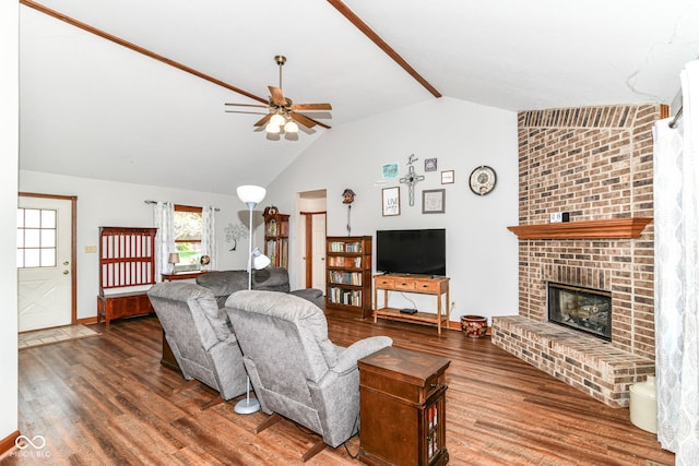 living area featuring a ceiling fan, wood finished floors, lofted ceiling, and a fireplace