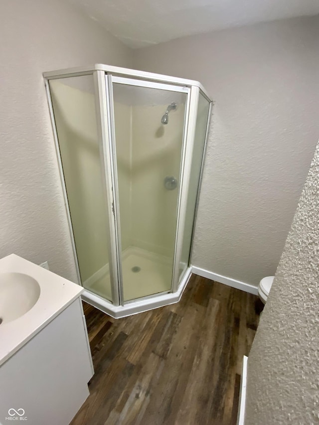 1019 E Jackson St, Shelbyville, IN 46176 - full bathroom with a textured wall, vanity, baseboards, wood finished floors, and a stall shower