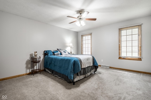 carpeted bedroom featuring visible vents, a ceiling fan, and baseboards