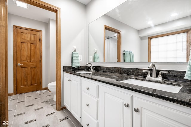 full bath with a sink, toilet, and double vanity