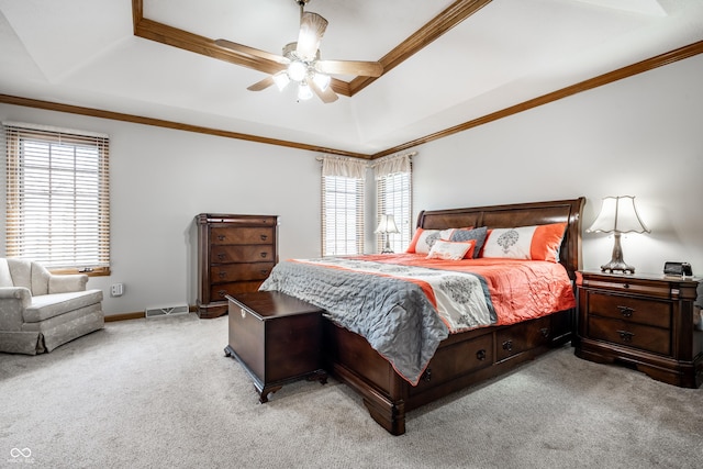 bedroom with ornamental molding, carpet, ceiling fan, and a tray ceiling