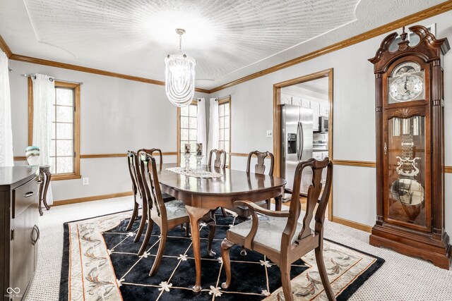 dining space with a notable chandelier, light colored carpet, ornamental molding, and baseboards