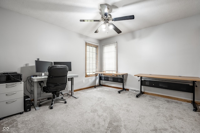 carpeted home office featuring baseboards and ceiling fan