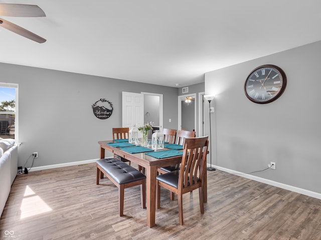 dining area featuring baseboards, a ceiling fan, and light wood finished floors