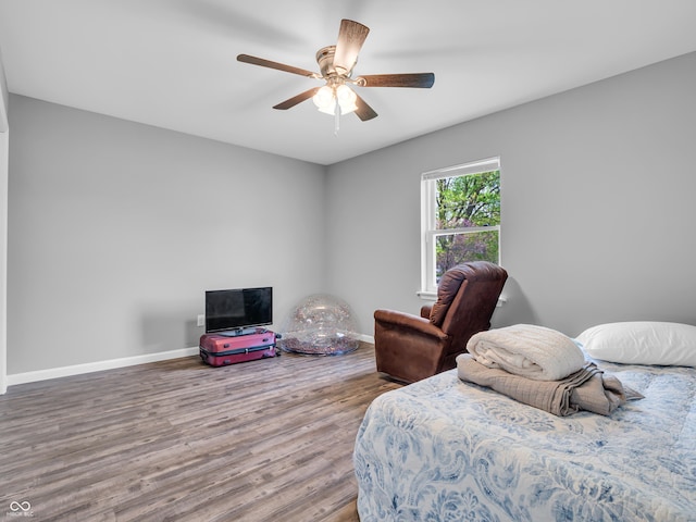 bedroom with wood finished floors, a ceiling fan, and baseboards