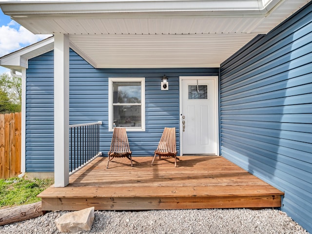 entrance to property featuring fence and a wooden deck