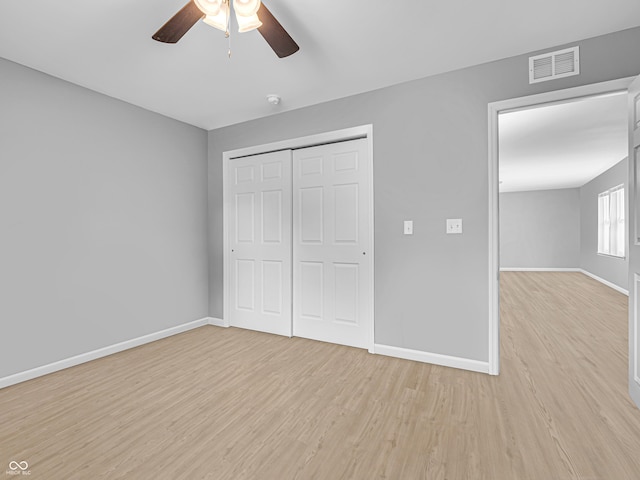 unfurnished bedroom featuring a closet, light wood-type flooring, baseboards, visible vents, and a ceiling fan