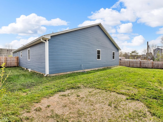 view of side of property with fence and a lawn