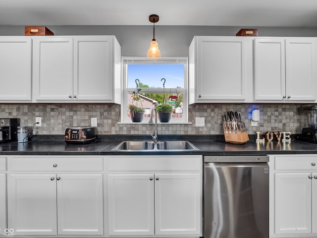 kitchen with white cabinets, dark countertops, dishwasher, and a sink