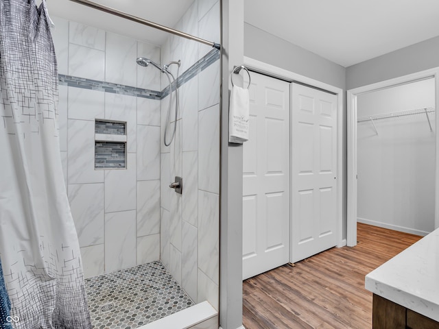 full bathroom featuring wood finished floors and a shower stall