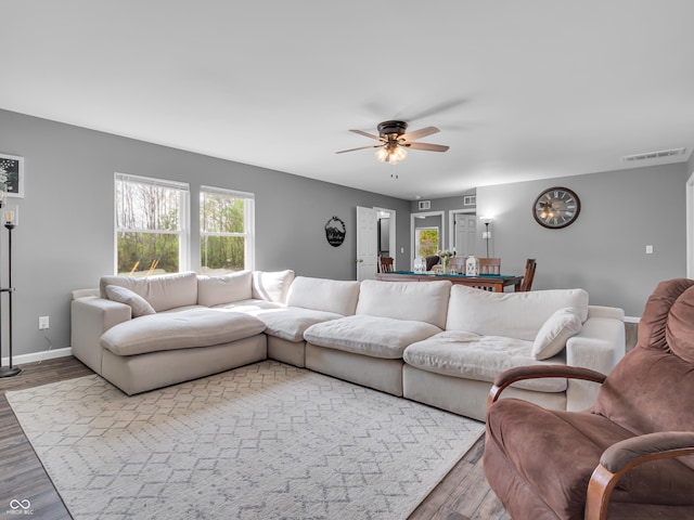 living area featuring visible vents, wood finished floors, a healthy amount of sunlight, and ceiling fan