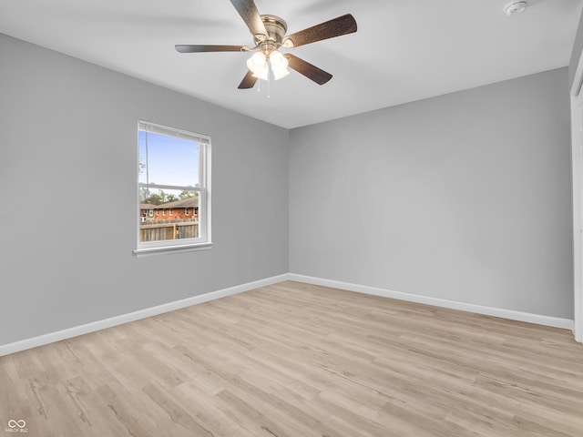 unfurnished room with baseboards, light wood-type flooring, and a ceiling fan