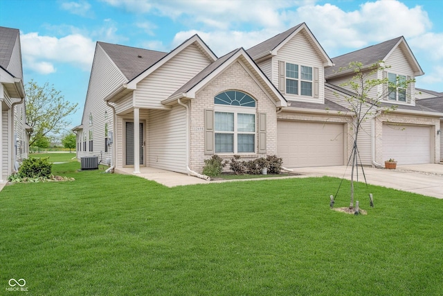 view of front of property with a front lawn, brick siding, a garage, concrete driveway, and cooling unit