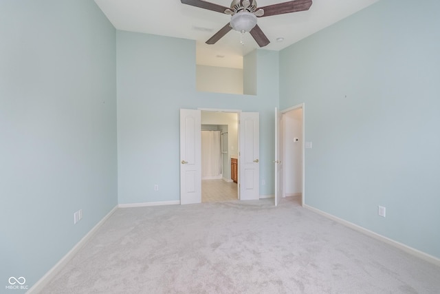 unfurnished bedroom with baseboards, a high ceiling, carpet, and visible vents