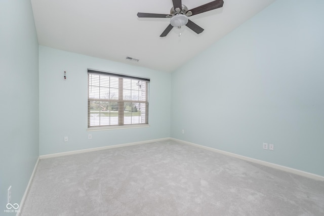 carpeted spare room with baseboards, a ceiling fan, lofted ceiling, and visible vents