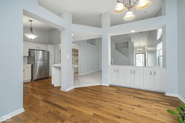 interior space with baseboards, a chandelier, and wood finished floors