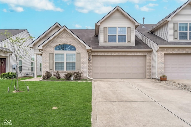 view of front of home featuring roof with shingles, an attached garage, a front lawn, brick siding, and driveway