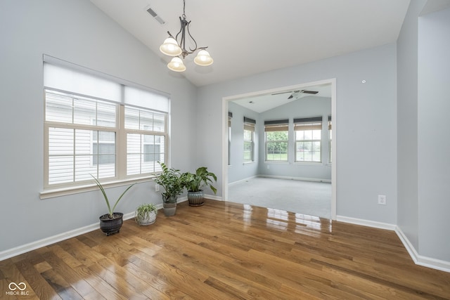 unfurnished room featuring baseboards, vaulted ceiling, and wood finished floors