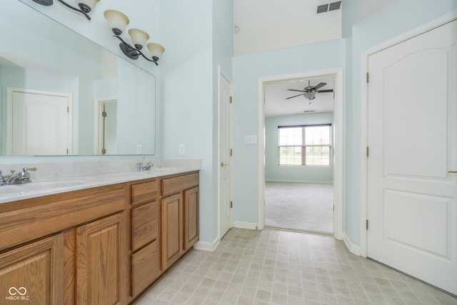 full bath with a sink, double vanity, a ceiling fan, baseboards, and visible vents