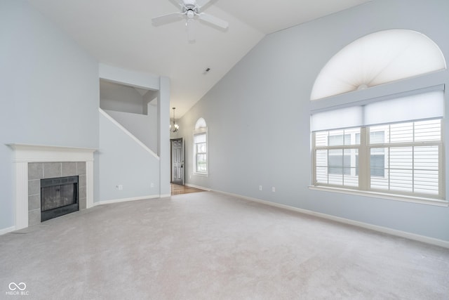 unfurnished living room with carpet floors, a ceiling fan, baseboards, and a tile fireplace