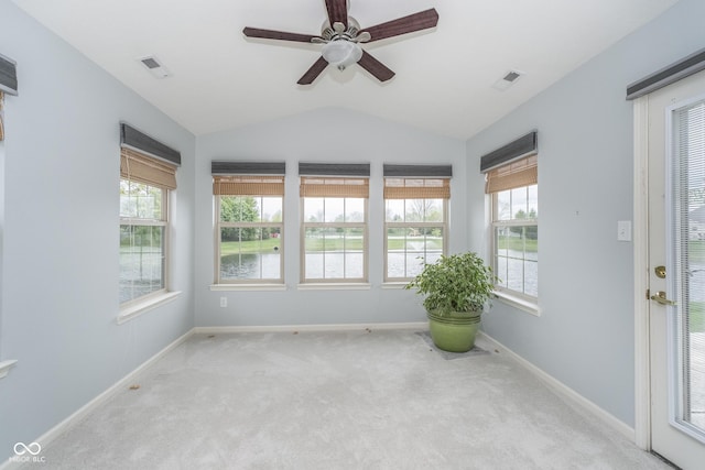 empty room featuring a ceiling fan, lofted ceiling, carpet flooring, and visible vents