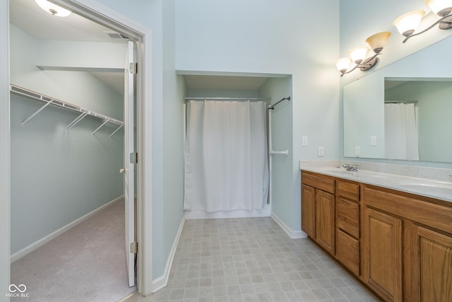 bathroom with a sink, baseboards, double vanity, and visible vents