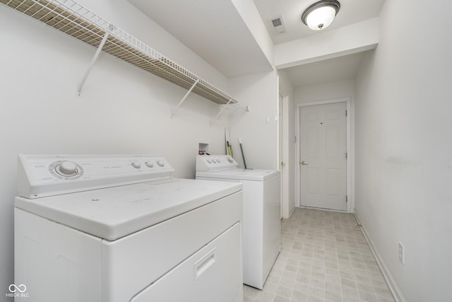 laundry area featuring laundry area, baseboards, light floors, visible vents, and washing machine and dryer