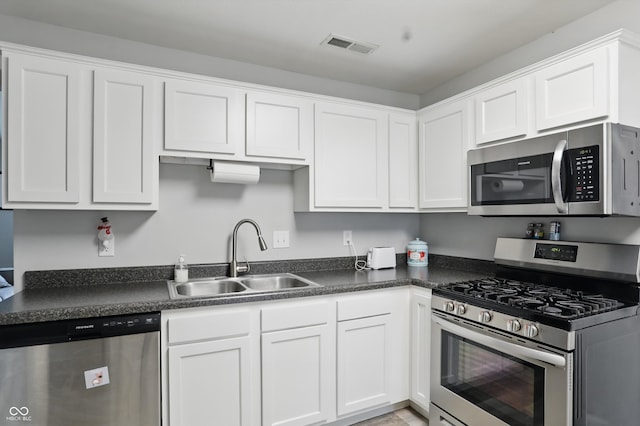842 Miller Ave, Shelbyville, IN 46176 - kitchen featuring white cabinets, stainless steel appliances, dark countertops, and a sink