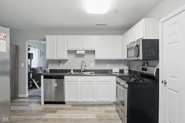 842 Miller Ave, Shelbyville, IN 46176 - kitchen featuring visible vents, dark countertops, a sink, light wood finished floors, and appliances with stainless steel finishes