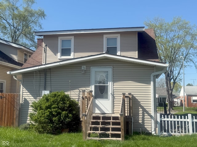 back of house featuring fence and roof with shingles
