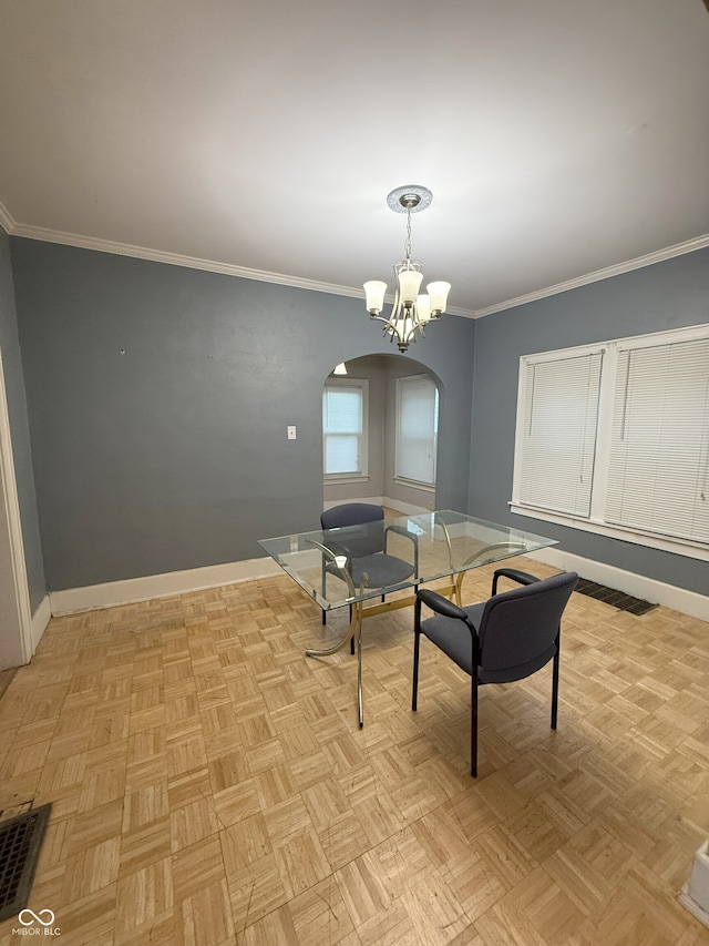 dining space with visible vents, baseboards, arched walkways, ornamental molding, and a notable chandelier