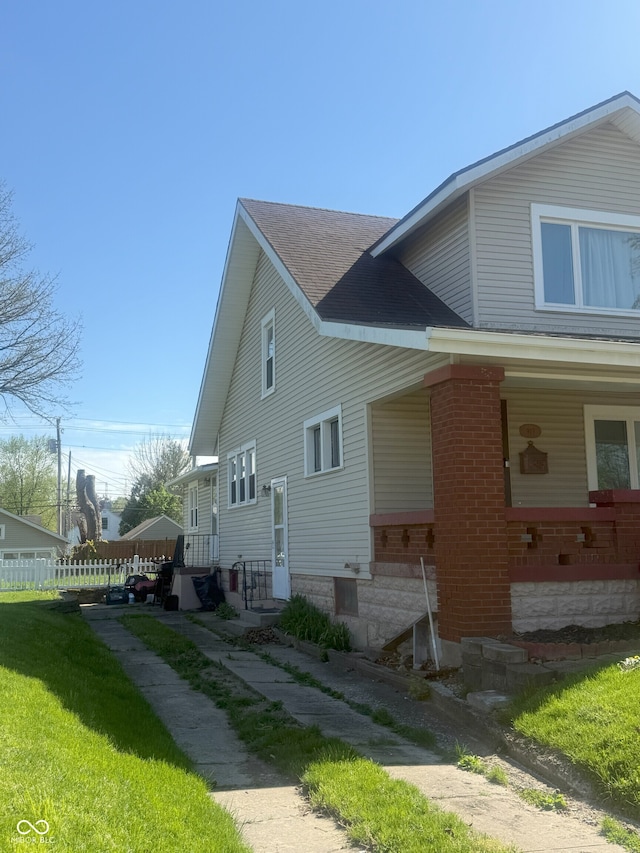 view of home's exterior featuring a shingled roof and brick siding
