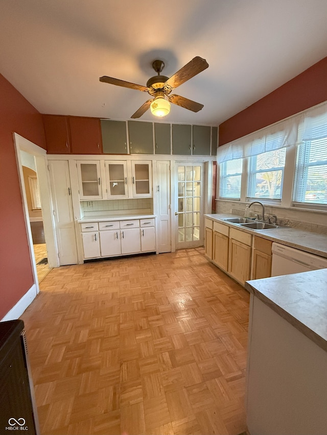 kitchen with light countertops, plenty of natural light, dishwasher, and a sink