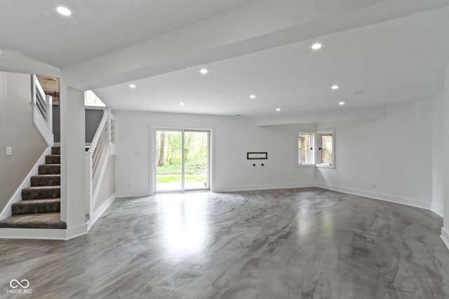 10919 Running Tide Ct, Indianapolis, IN 46236 - unfurnished living room featuring healthy amount of natural light, stairs, recessed lighting, baseboards, and finished concrete flooring
