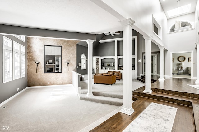 10919 Running Tide Ct, Indianapolis, IN 46236 - entryway with decorative columns, a ceiling fan, dark wood-style floors, a towering ceiling, and a skylight