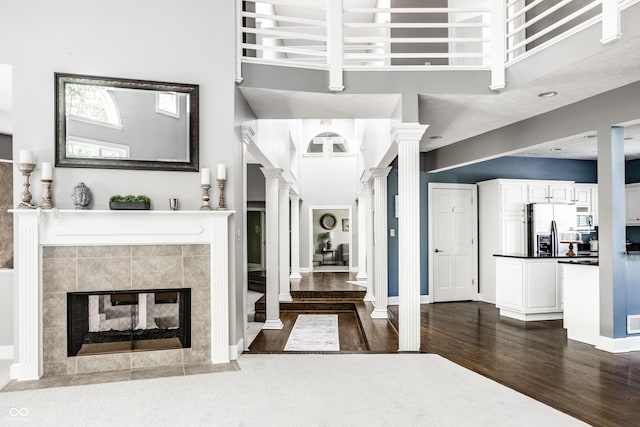 10919 Running Tide Ct, Indianapolis, IN 46236 - foyer entrance featuring dark wood-style flooring, a high ceiling, ornate columns, and a tiled fireplace