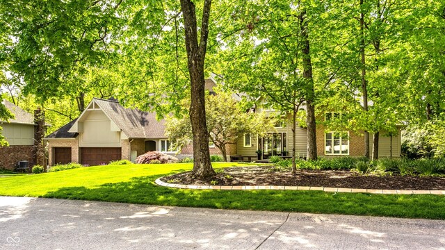 10919 Running Tide Ct, Indianapolis, IN 46236 - obstructed view of property featuring a front lawn, brick siding, a garage, and roof with shingles