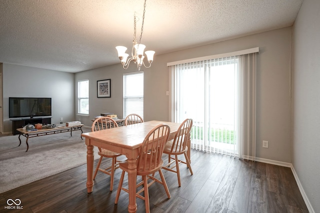 dining area featuring baseboards, a textured ceiling, a chandelier, and dark wood finished floors