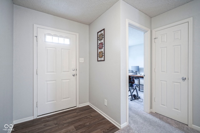 foyer with baseboards, a textured ceiling, and dark wood-type flooring