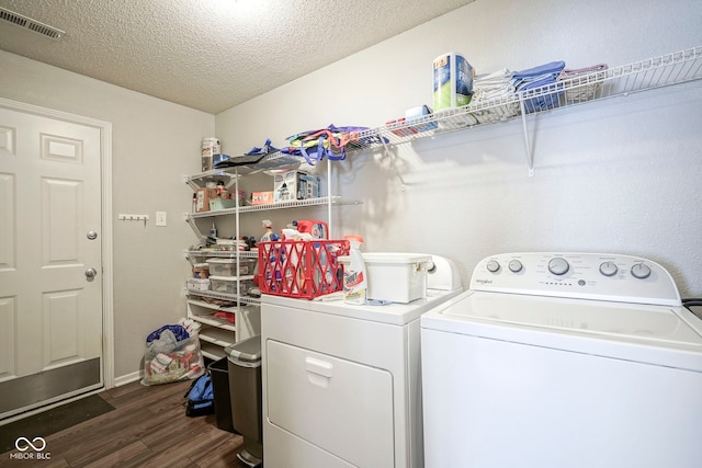 laundry room featuring laundry area, dark wood-style floors, a textured ceiling, baseboards, and washing machine and dryer