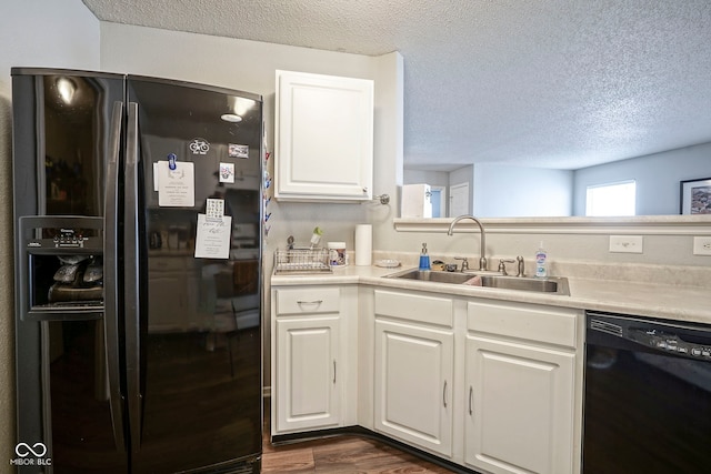 kitchen with a sink, black appliances, a textured ceiling, and dark wood-type flooring