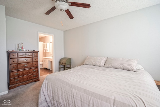bedroom featuring carpet flooring, a ceiling fan, a textured ceiling, and connected bathroom